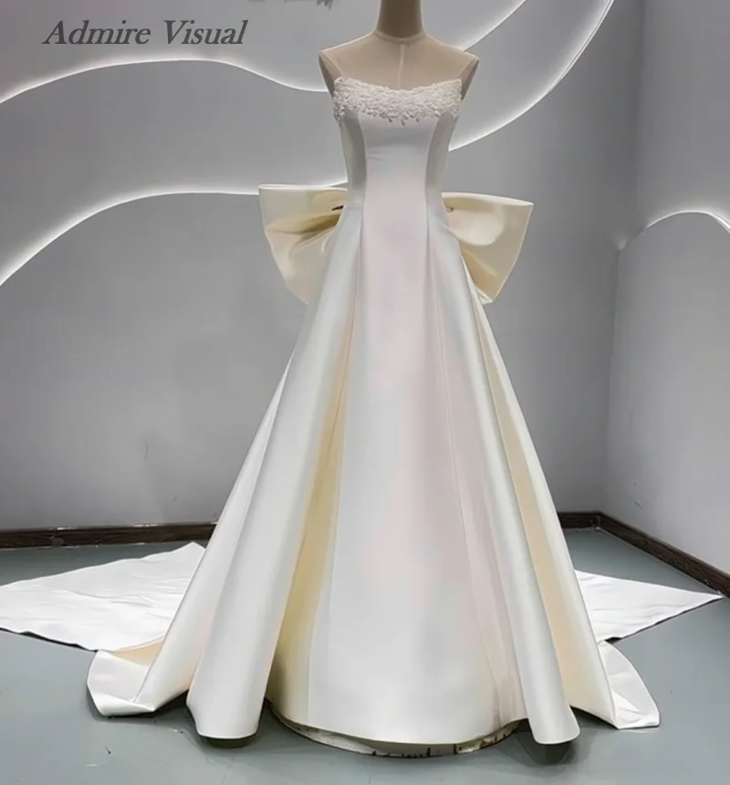 분리 가능한 큰 리본이 달린 A라인 새틴 민소매 비주얼 웨딩드레스를 감상하세요. 맞춤 제작 가능한 신부 가운