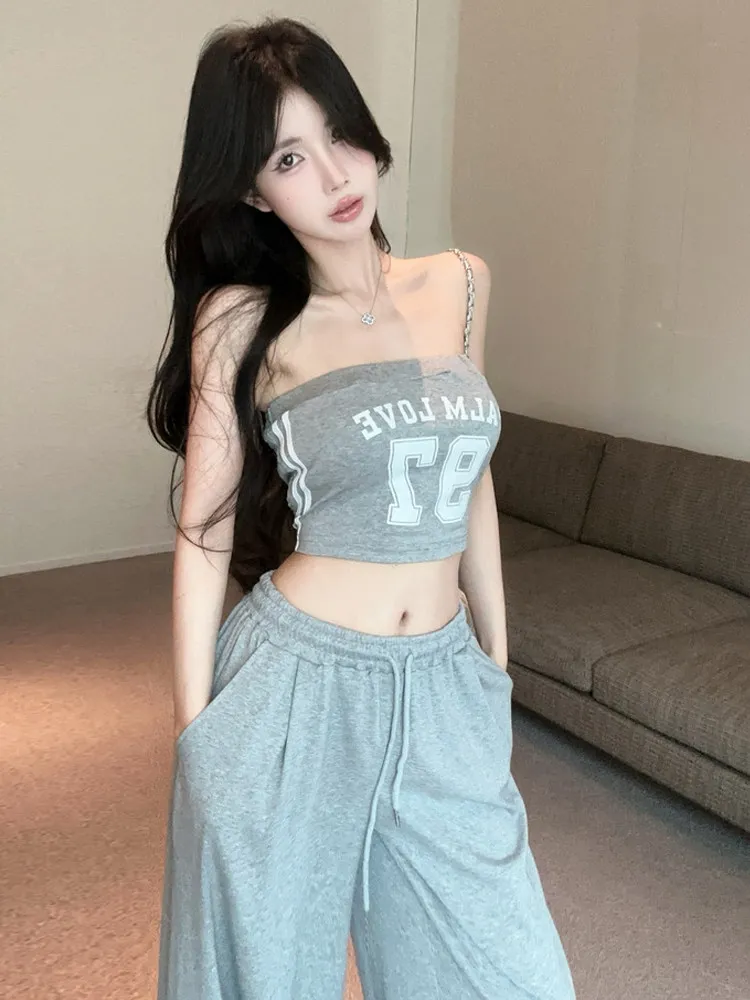 

Спортивный стиль, повседневная мода, комплект из двух предметов: топ без бретелек с контрастным буквенным принтом и прямые широкие брюки.