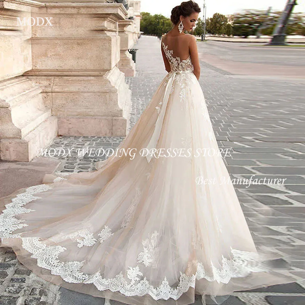 

MODX Transparent Scoop Champagne Wedding Dresses with Detachable Beading Sash Lace Applique Sleeveless Backless Bridal Gowns