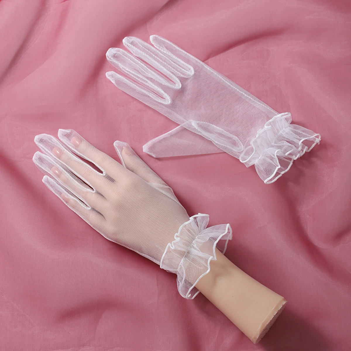 Ein Paar transparente Handschuhe im Fingerstil, geeignet als Zubehör für Braut hochzeiten oder Frauen tänze