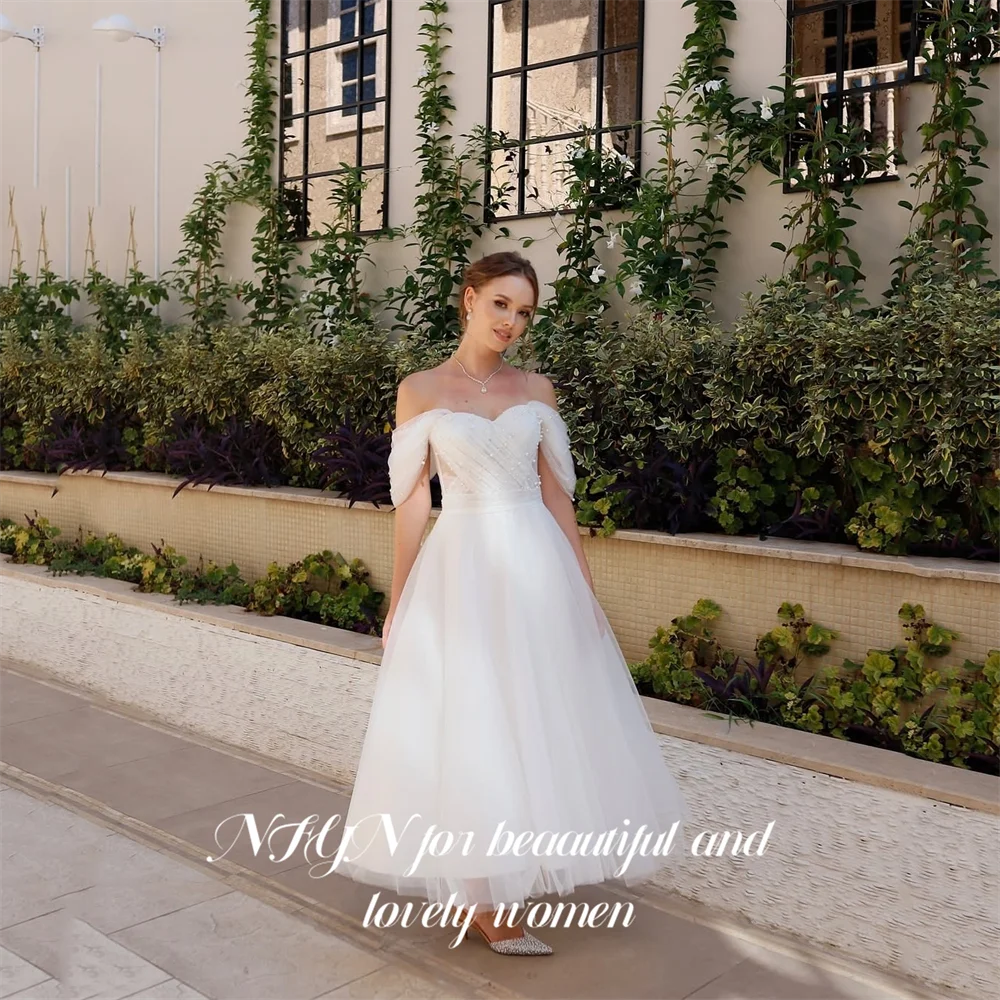 ชุดราตรีสีขาว NFYN แบบเปิดไหล่ ความยาวระดับชา พร้อมผ้าทูลล์คลุมและประดับลูกปัด สำหรับงานแต่งงาน สามารถสั่งตัดได้