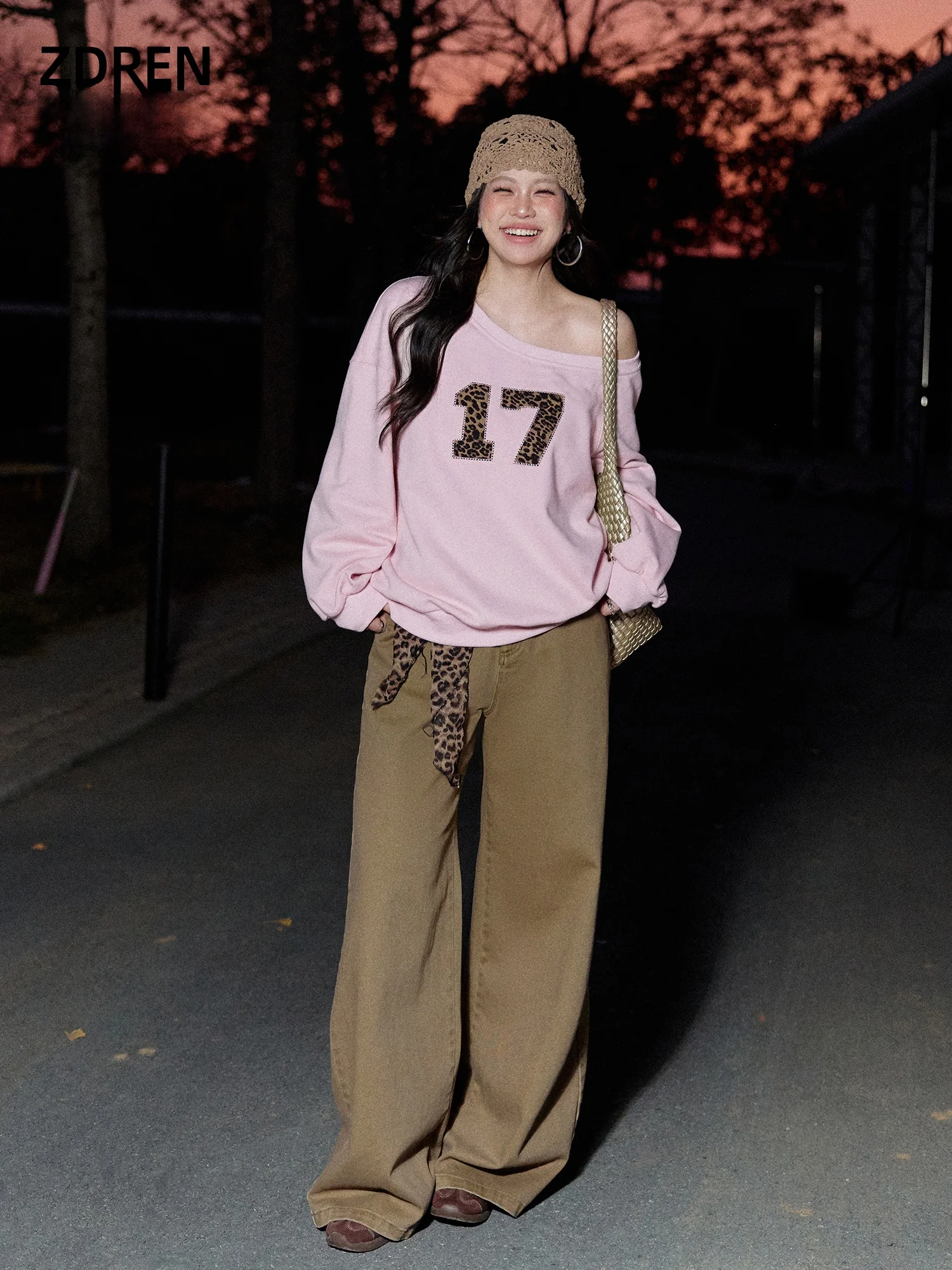 

Женский комплект больших размеров: розовый свитшот с асимметричным вырезом на плече и коричневые брюки, корейский стиль, модный весенний наряд больших размеров.