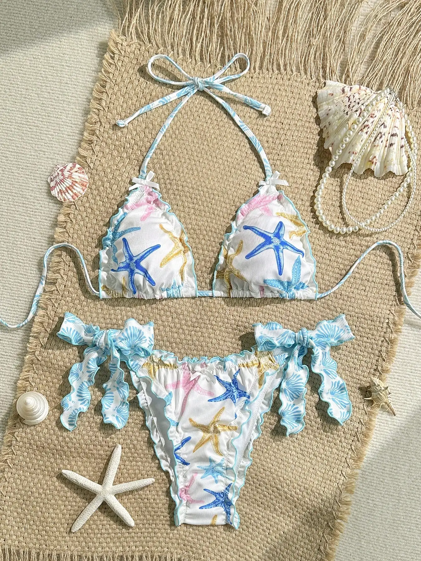 

Женский комплект бикини из двух частей с треугольными топами на бретелях, принтом в виде морских звезд и рюшами по краю.