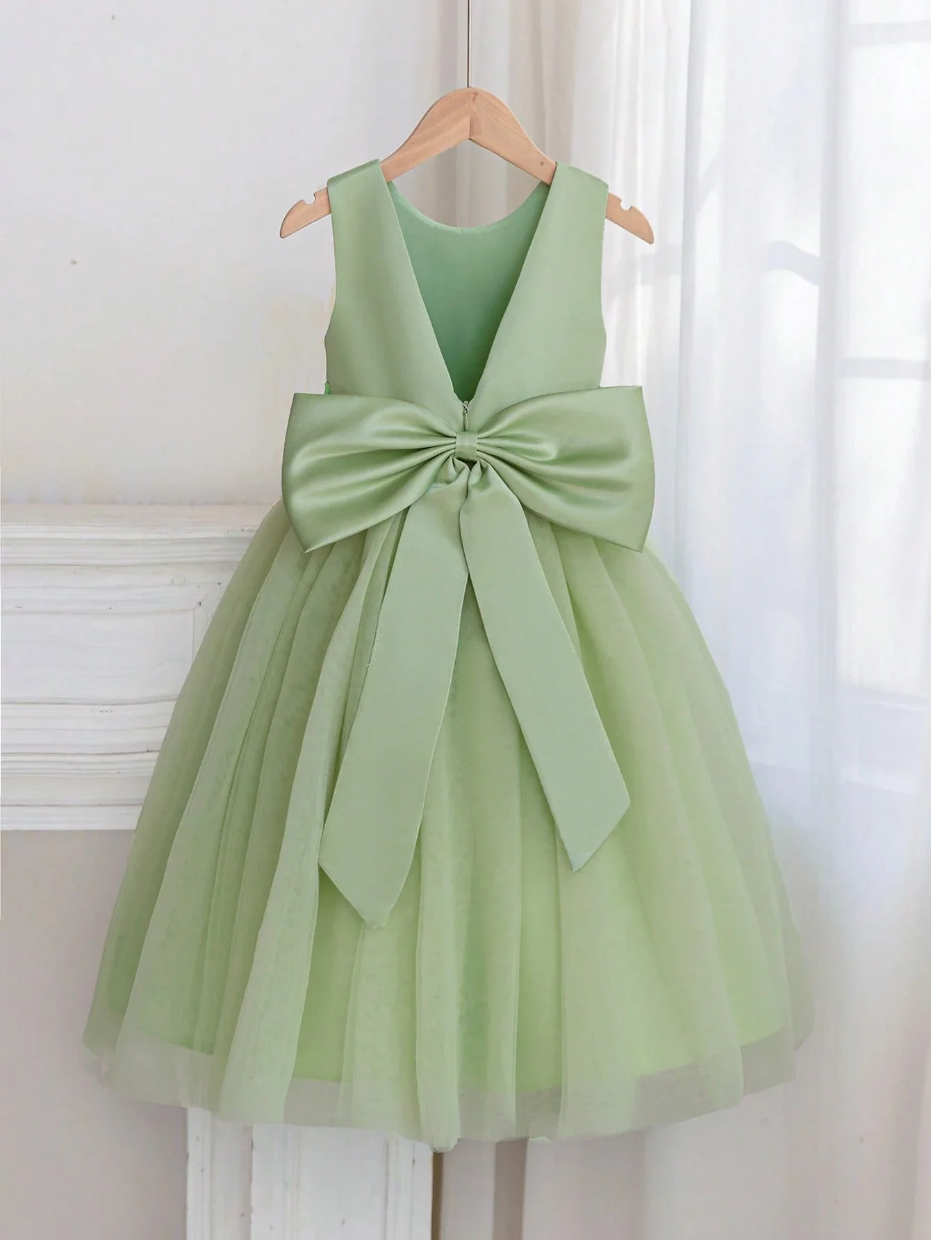 

Светло-зеленое вечернее платье без рукавов с бантом и юбкой из фатина