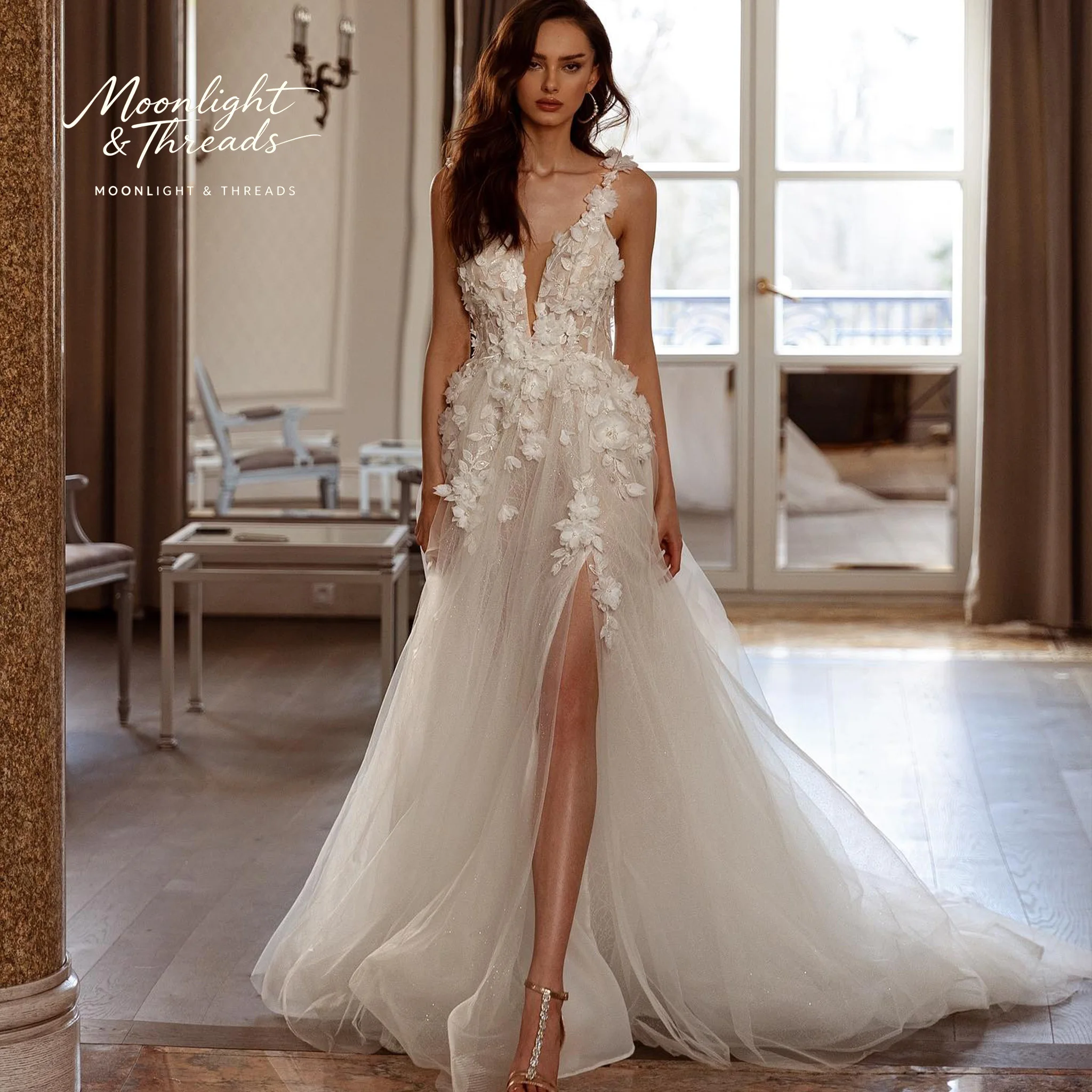 Ivory floor-length formal wedding gown featuring a strapless open-back design appliqué detailing and a voluminous skirt
