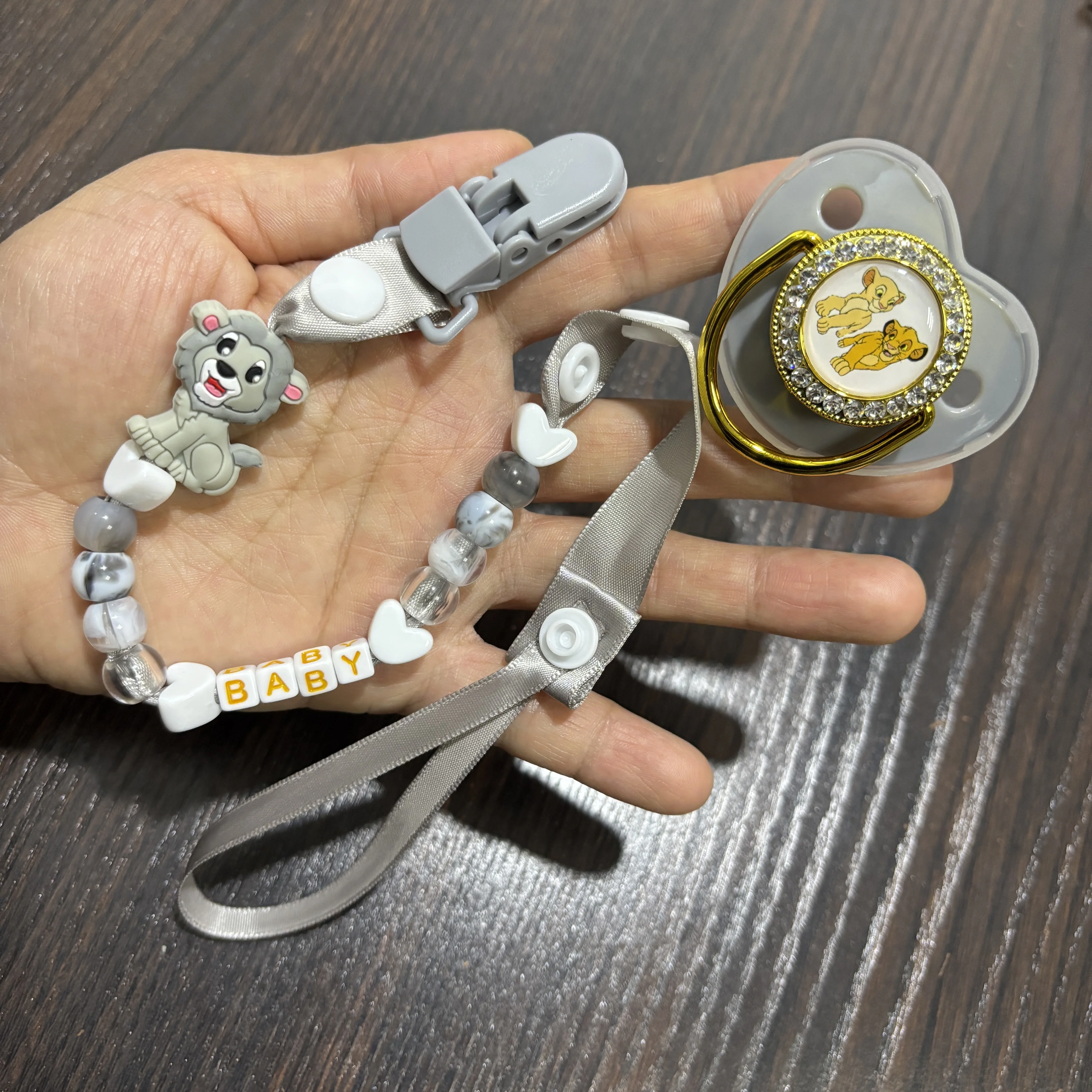 

A cartoon baby chewing on a pacifier and a baby wearing a chain of pacifiers baby teeth A cute and practical newborn bib for new