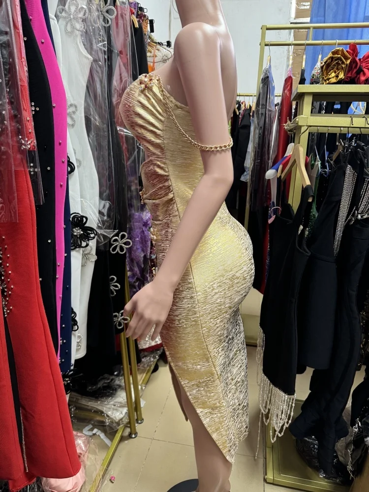 新しい高品質でセクシーなゴールドのワンショルダーカラードレス。背中が露出するカットアウトデザイン、プリーツ、ゴールドカラーが特徴です。
