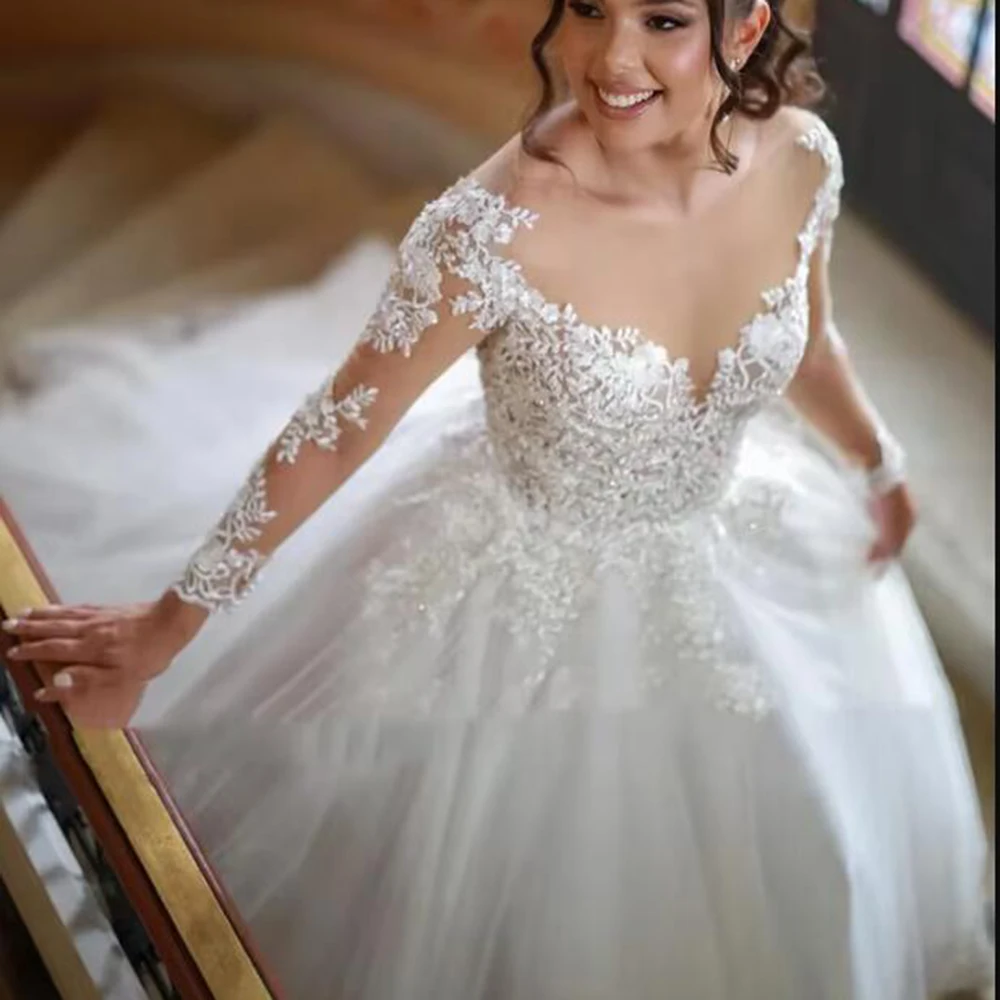 Eleganckie suknie ślubne w kształcie litery A z koronkowymi aplikacjami i koralikami, z iluzorycznymi długimi rękawami i dekoltem typu iluzja, szyte na miarę.