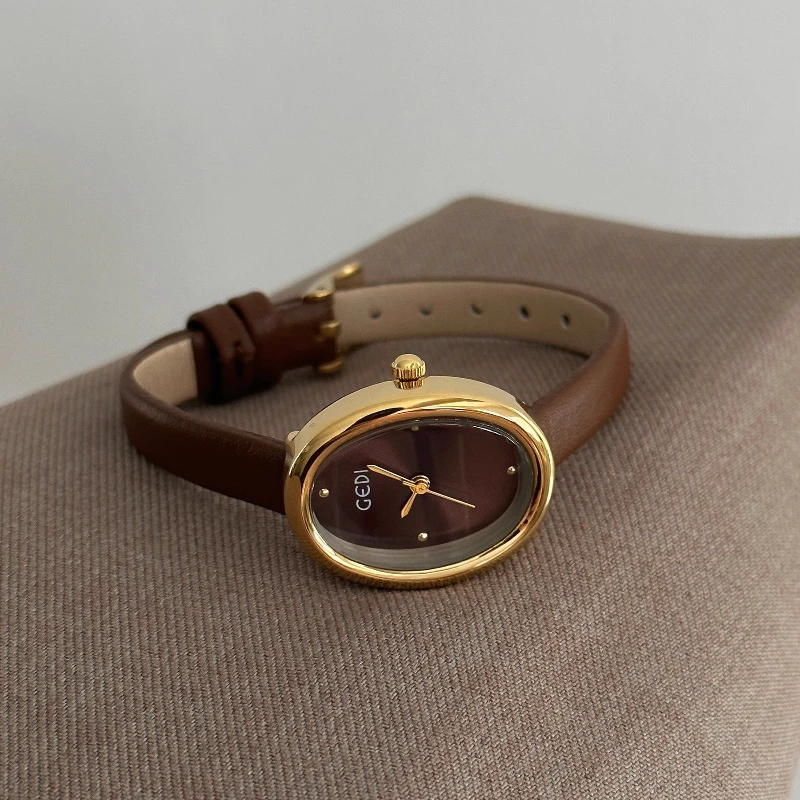 ساعة ريترو براون للنساء 2025 جديدة فاخرة بيضاوية صغيرة الطلب موضة جلدية السيدات ساعة ذهبية الراقية ساعة كوارتز