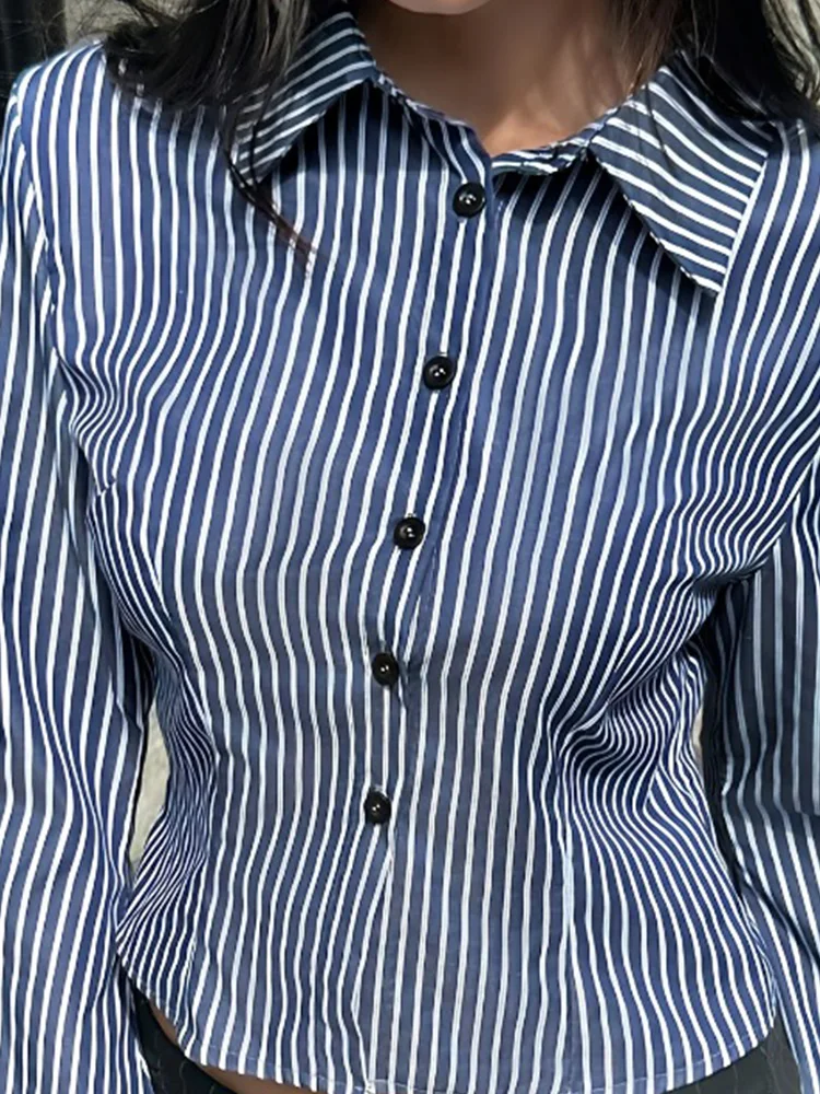 بلوزة نسائية بياقة قميص وأكمام منتفخة قصيرة بخطوط عمودية زرقاء داكنة، تصميم بسيط بأكمام واسعة قليلاً وخصر ضيق