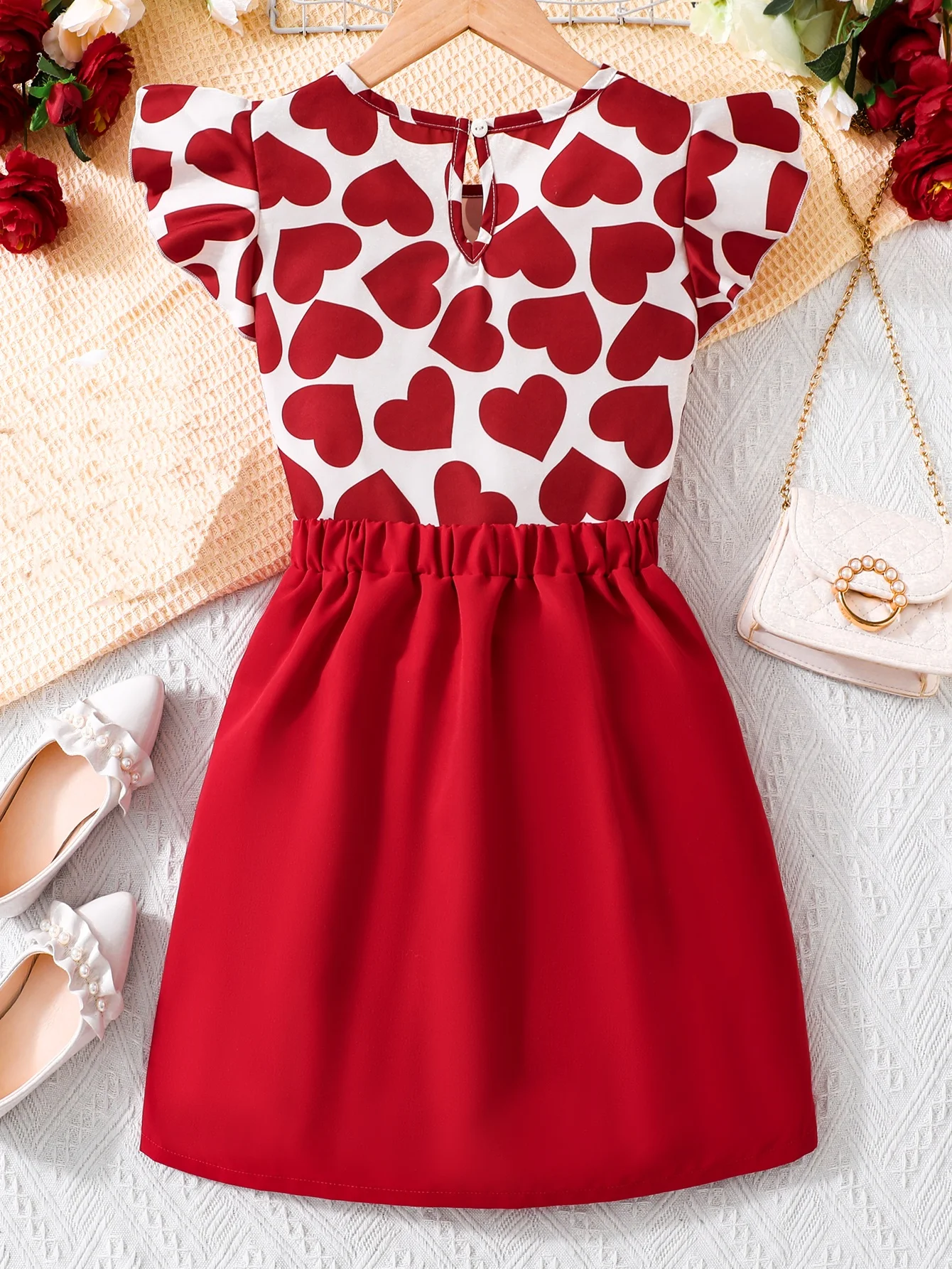 Abito da ragazza alla moda con stampa a cuore: abbinamento di colori rosso e bianco e design sul petto sul davanti