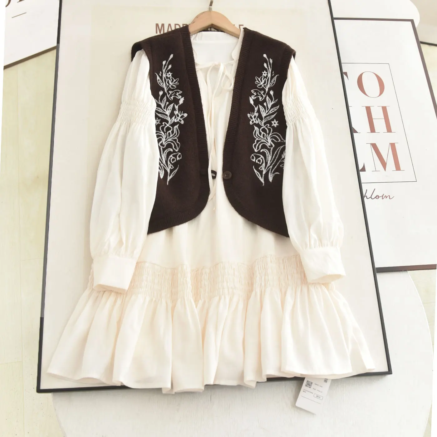 

Женский комплект из двух предметов: вязаный жилет с вышивкой и V-образным вырезом, а также юбка с поясом, омолаживающий образ, весенняя мода