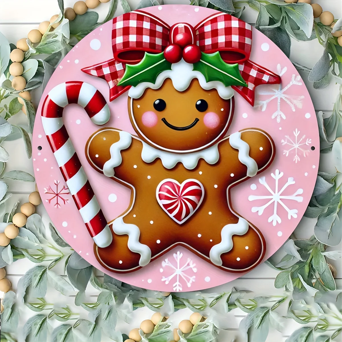 A Round Metal Sign Featuring a Pink And Red Gingerbread Christmas Wreath, Suitable for Home, Bar, Or Cafe Decoration, Measuring