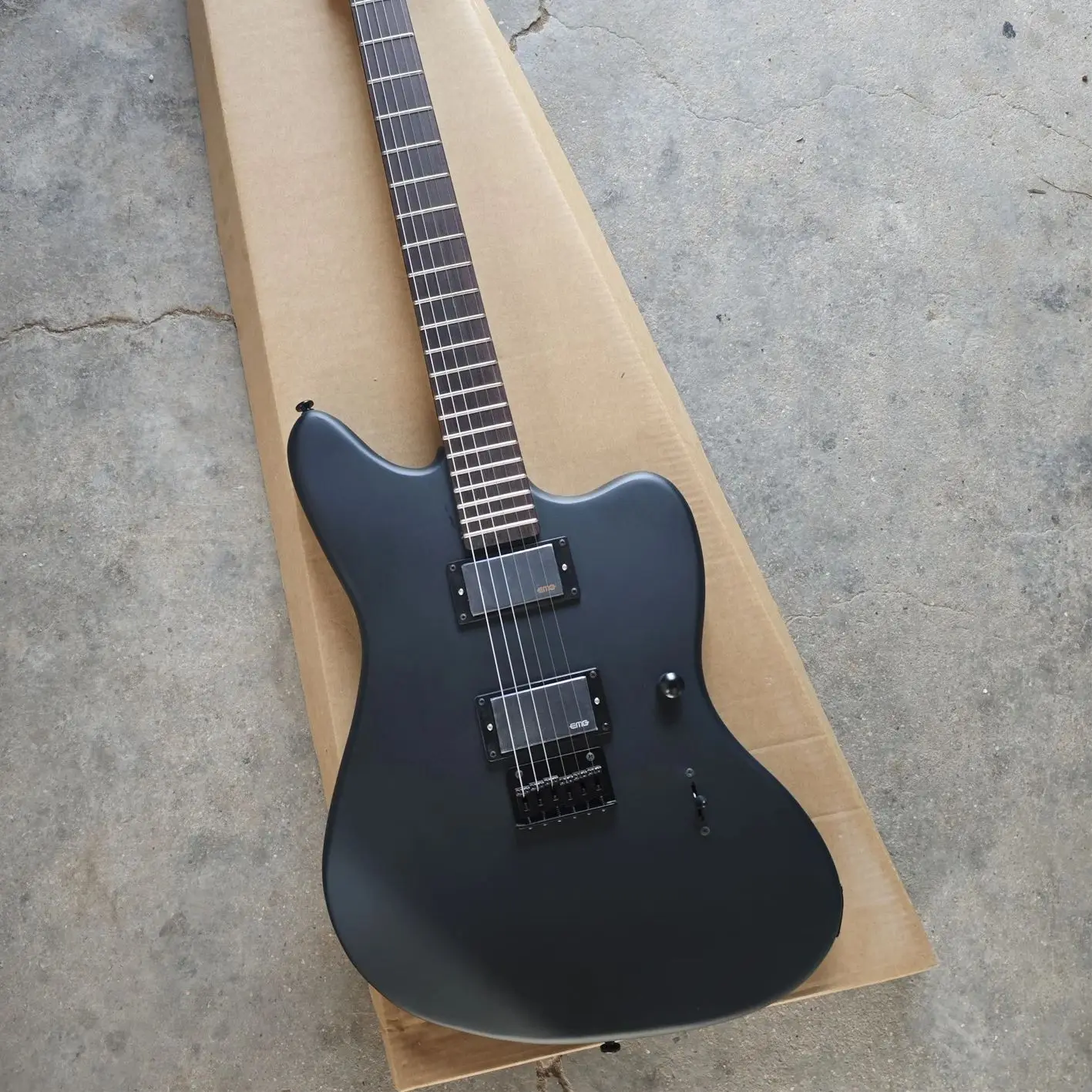 Black six-string electric guitar with matte paint, basswood body, maple neck and rose wood fingerboard.