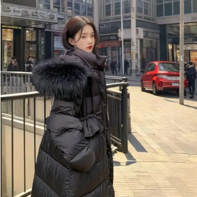 2026 سترة طويلة للنساء الشتاء مقنعين مع كبيرة الفراء طوق Cinched الخصر جديد الراقية معطف دافئ الوردي الملابس النسائية