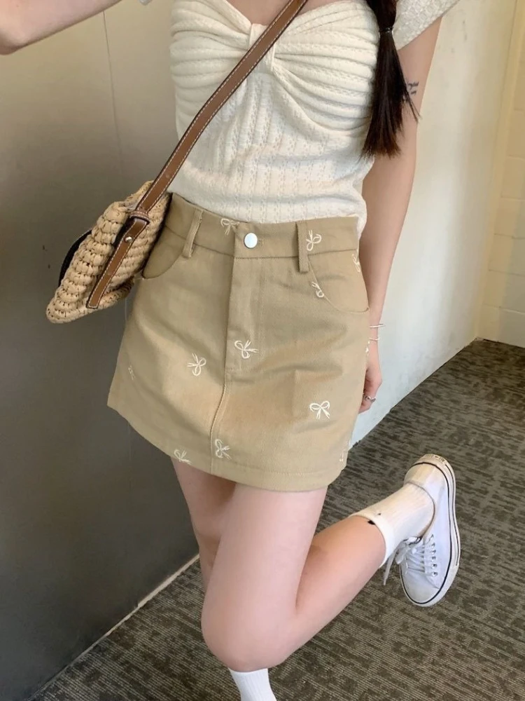 

Новая женская джинсовая юбка цвета хаки на лето, с высокой талией, А-силуэта, короткая, с вышивкой бантом, подчеркивающая фигуру, с защитой от просвечивания