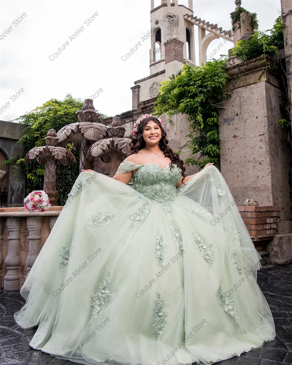 فستان Quinceanera مزين بالدانتيل باللون الأخضر المريمية بدون أكتاف مشد برباط مع فيونكة كرة سندريلا المكسيكية حسب الطلب