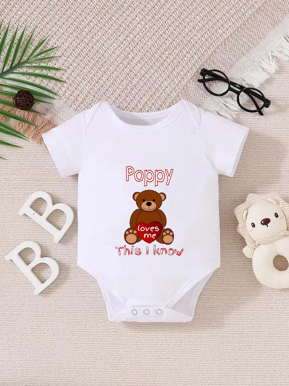 Playful letter-printed baby short-sleeve triangle bodysuit. Button closure for easy dressing, machine washable