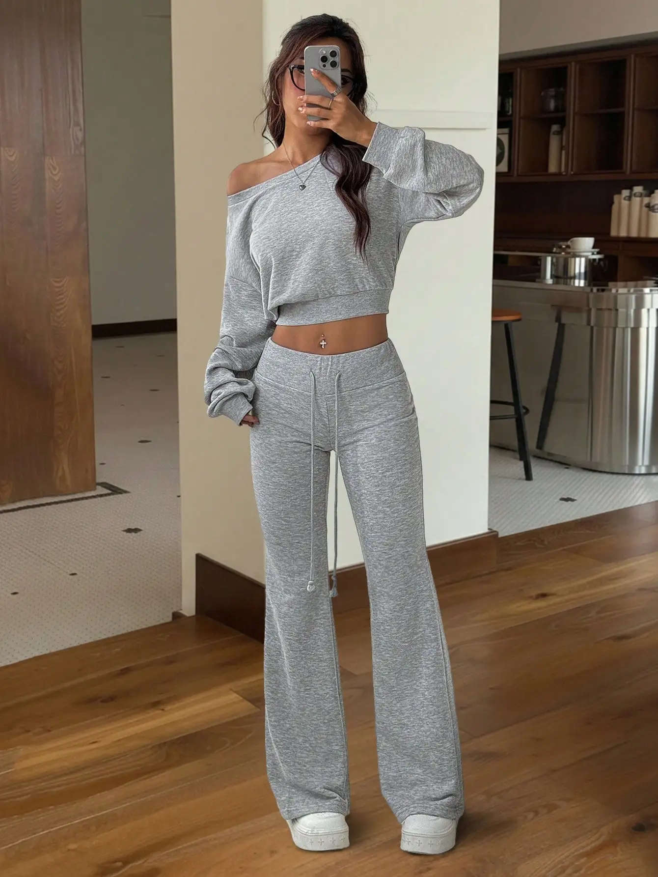 

Женский серый комплект: укороченный топ с асимметричным вырезом на плече и расклешенные спортивные брюки