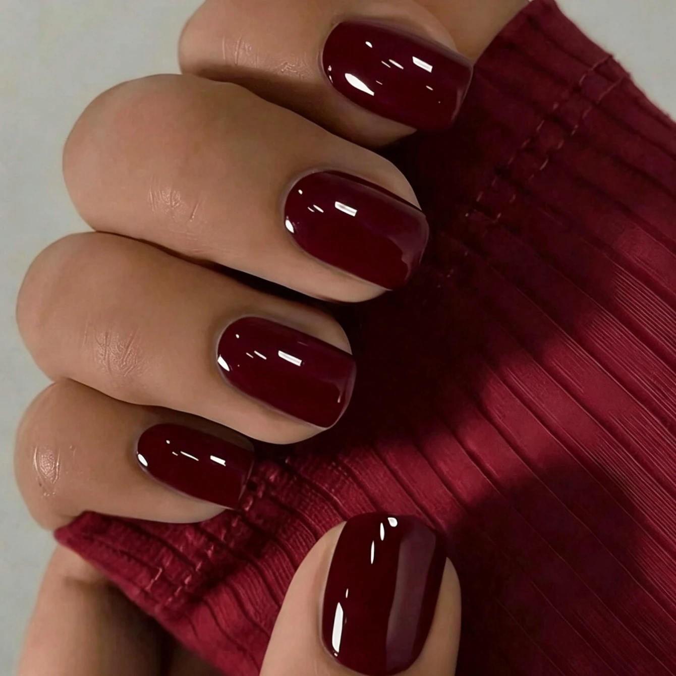 A complete set of 24 short square fake nails, designed with glossy wine red solid color, including 1 jelly glue and 1 nail file.