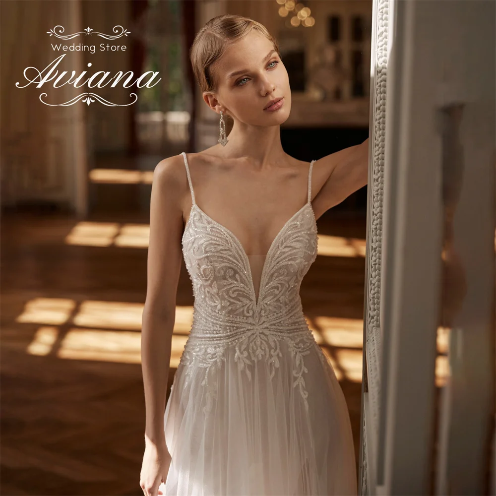 فستان زفاف مخصص من Aviana مزين بالدانتيل على شكل حرف a عميق على شكل حرف v وحزام سباغيتي سويب تراين ترتر بفتحة جانبية عالية من التل