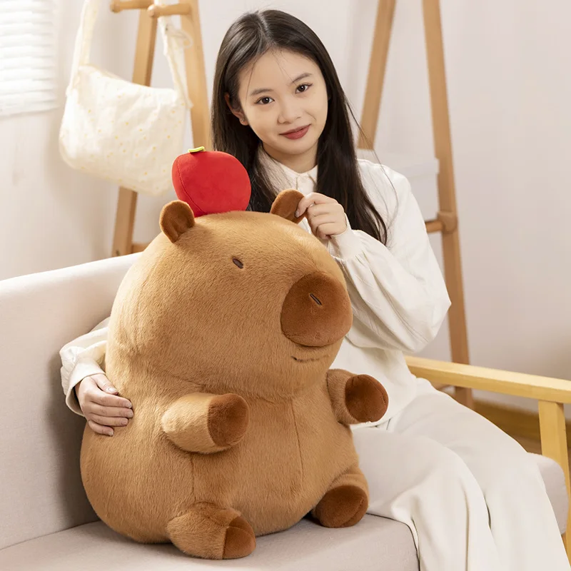 สีน้ําตาลนั่ง Capybara ตุ๊กตาสัตว์น้ํากับแอปเปิ้ลแดงบนหัวของเล่นตุ๊กตาไขมันปัจจุบัน