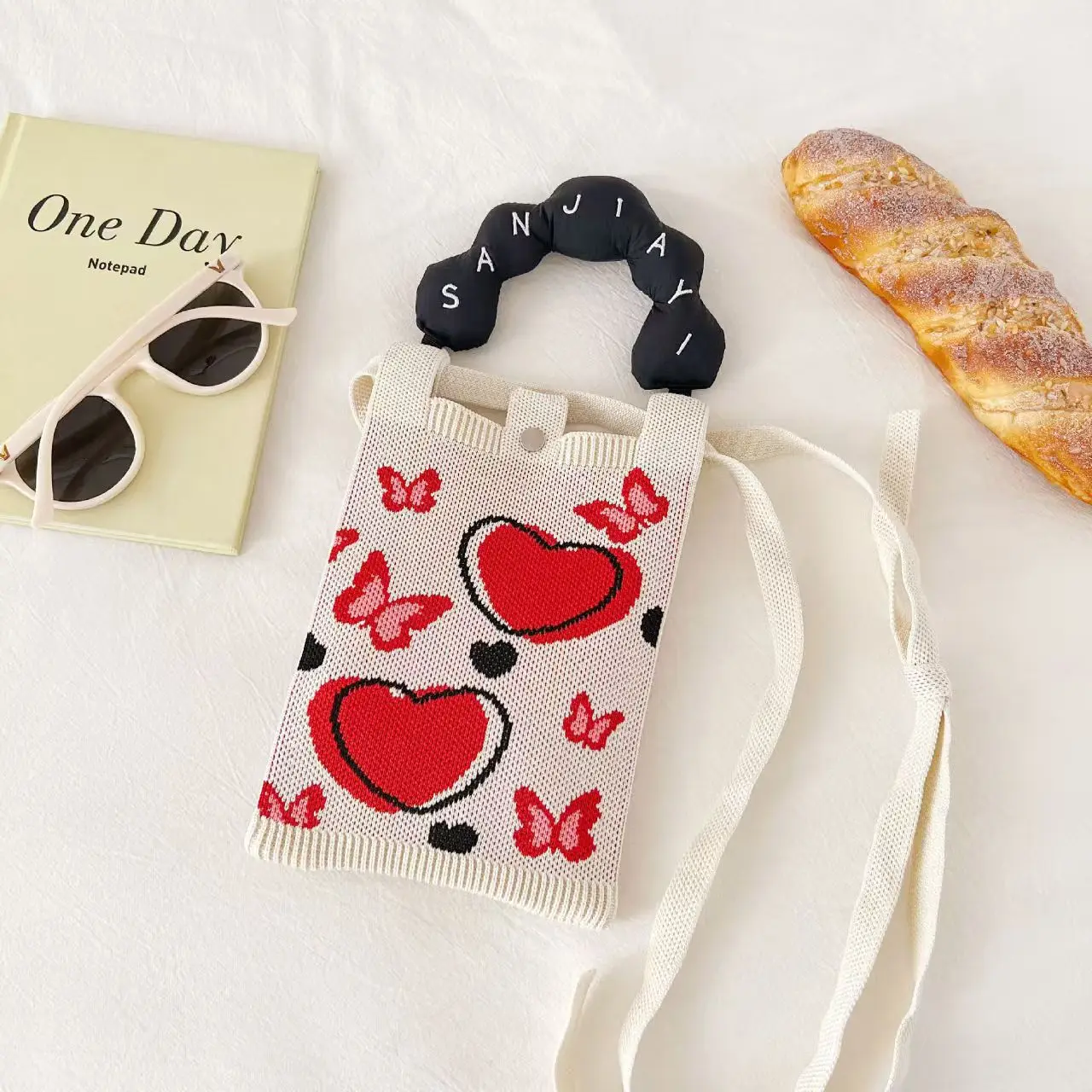 حقيبة معصم أنيقة بتصميم كرتوني محبوك، مصنوعة من البوليستر المتين مع إغلاق داخلي بمشبك، تصميم عمودي لحمل الهاتف المحمول للمراهقين