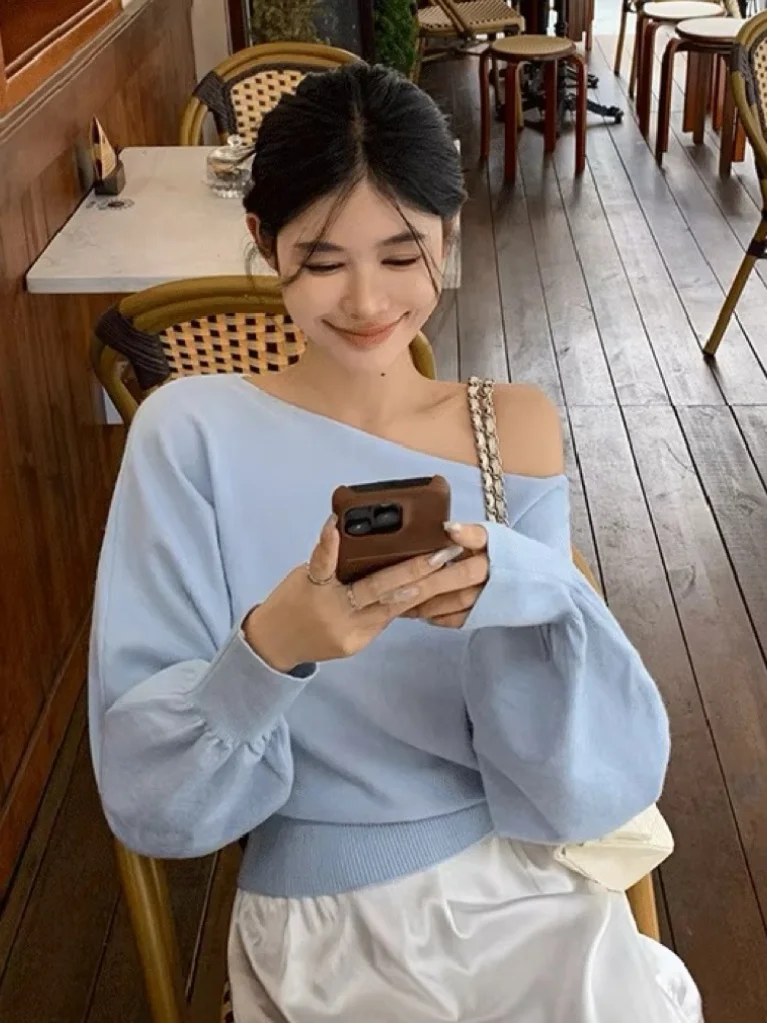 سترة نسائية زرقاء فاتحة محبوكة بأكمام طويلة وكتف واحد، تصميم رقيق وأنيق، موديل خريفي جديد للارتداء في الداخل والخارج