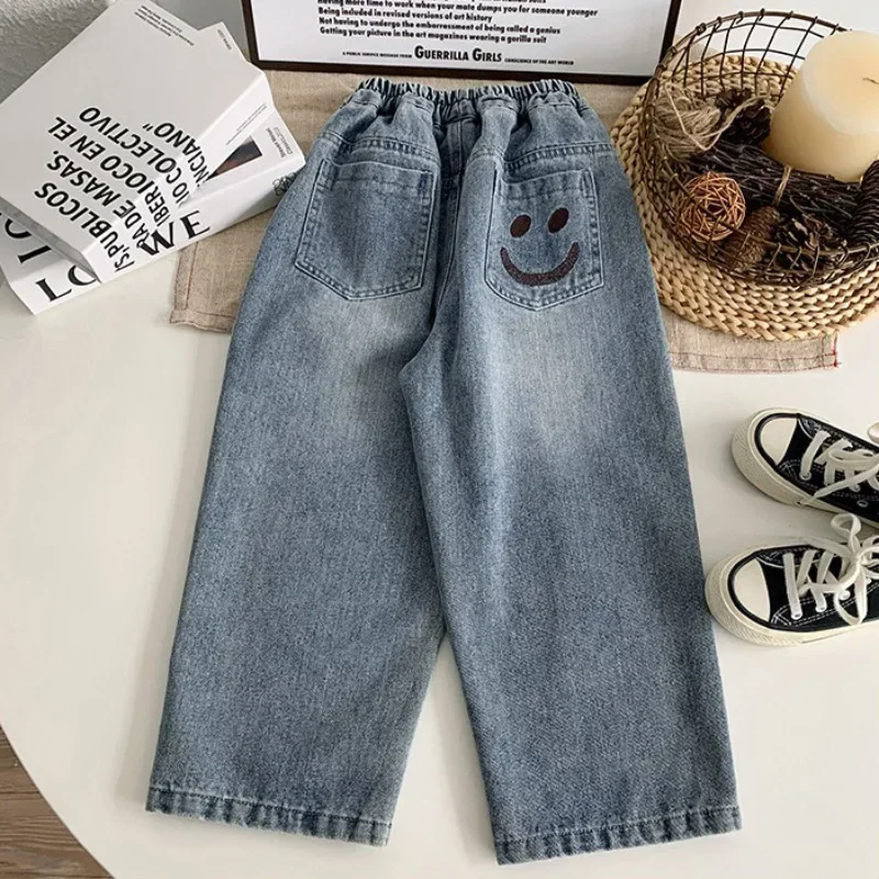 Novo 2025 meninos moda rosto sorridente bordado jeans calças compridas criança clássico solto calças jeans crianças primavera outono roupas