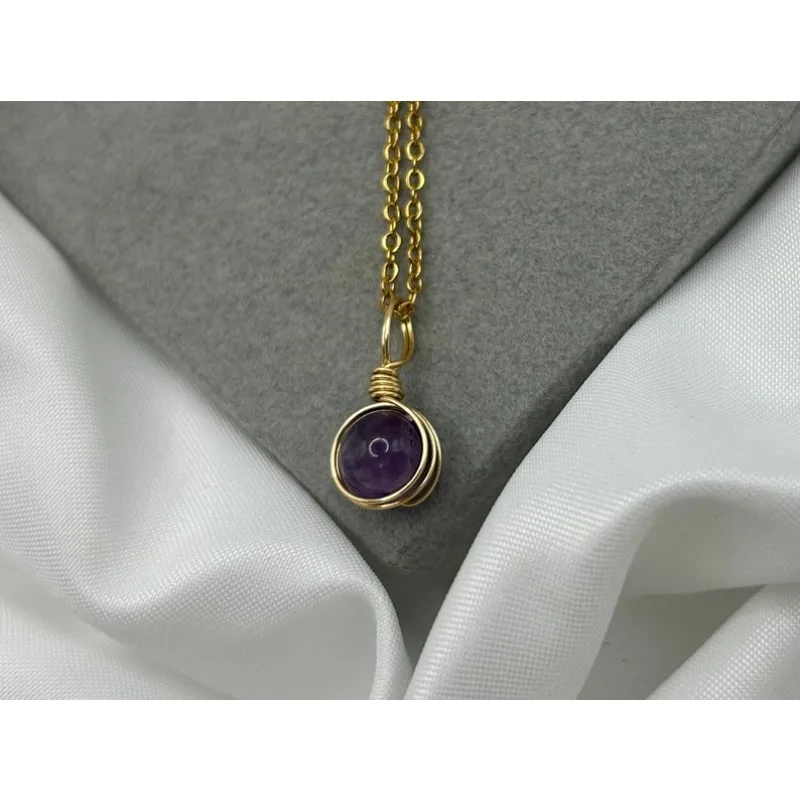 Gold amethyst necklace: A healing crystal pendant wound with metal wires