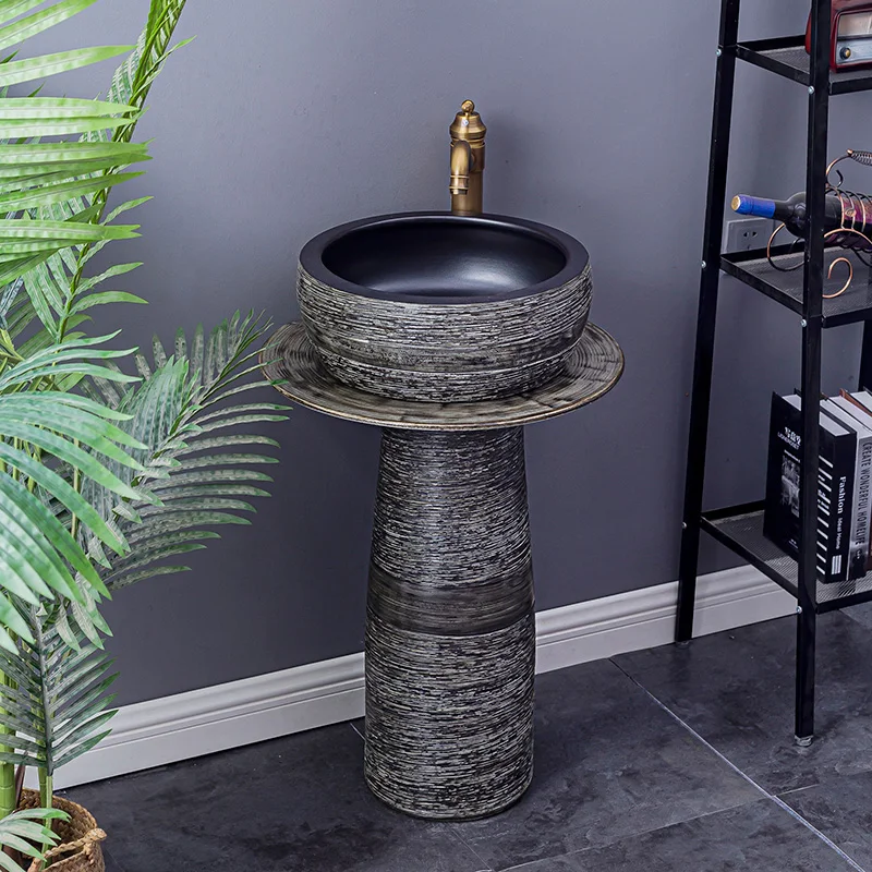 

Ceramic pillar-type wash basin is floor-to-ceiling outdoors