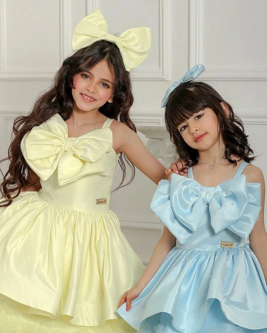 فستان فتاة الزهور لحفلات أعياد الميلاد من الساتان الأصفر بدون أكمام مع فيونكة من التل ريفلز فستان التواصل الأول حسب الطلب