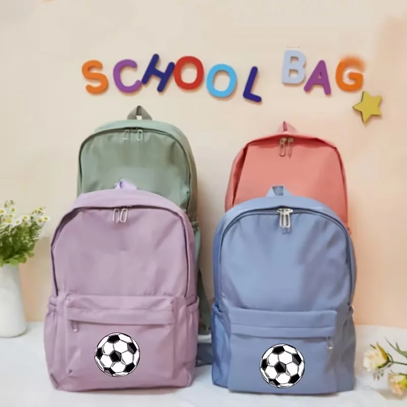 Una linda mochila escolar con temática de dibujos animados y estampado de balón de fútbol, perfecta para el uso diario en el colegio.