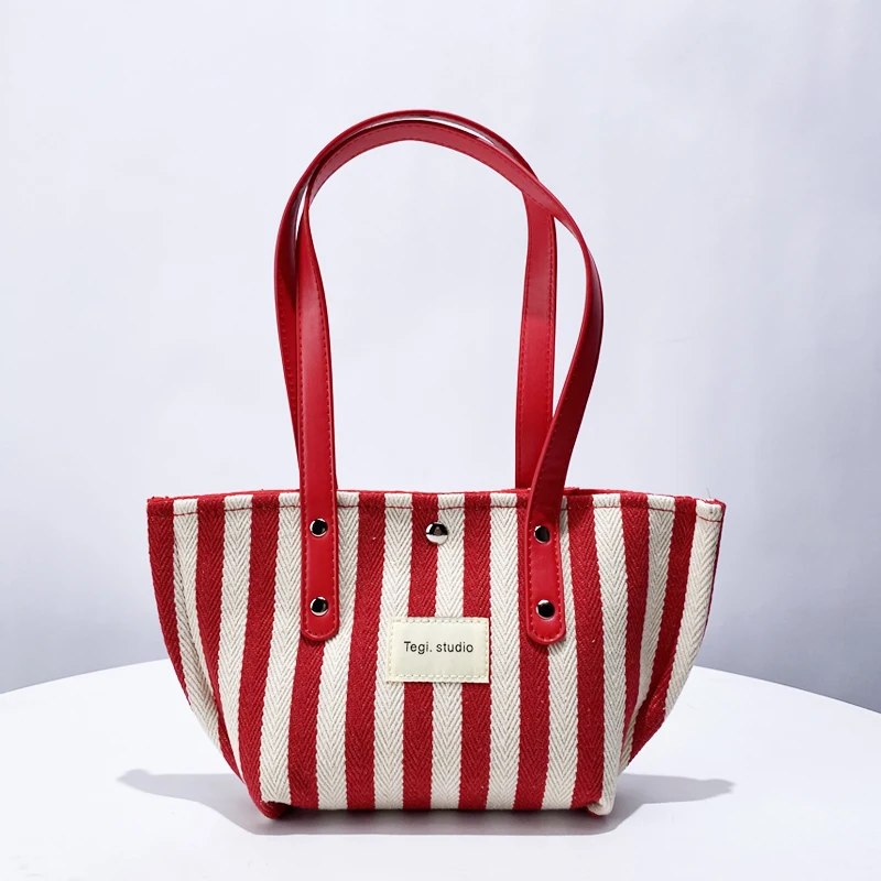 Bolsos de lona a rayas de estilo japonés para mujer bolsos y monederos de diseñador de lujo novedad de 2024 en letras decoración de colores contrastantes bolso de hombro pequeño de tela para las axilas alta calidad