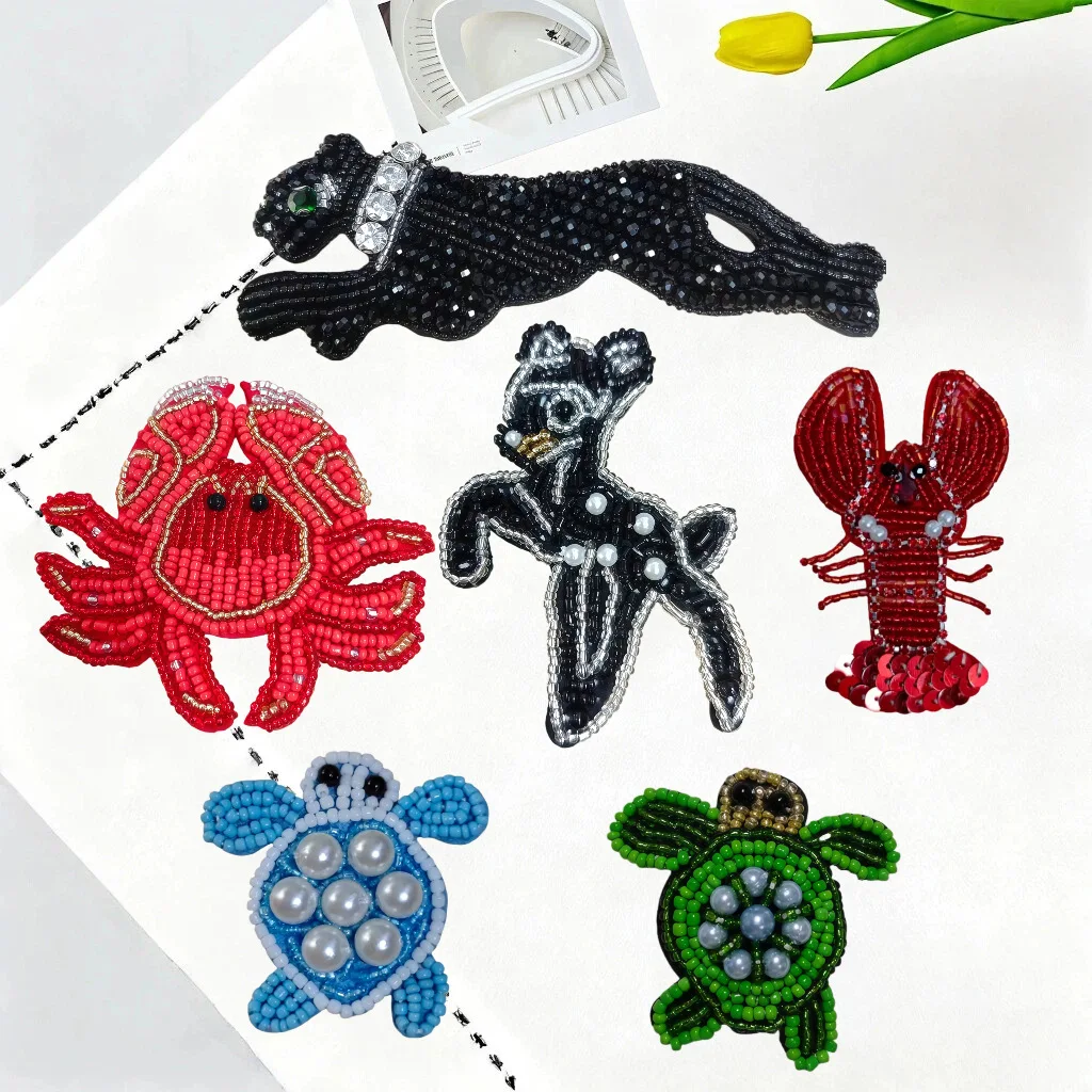 Cute marine animal appliqués featuring crabs, lobsters, and deer, adorned with beaded embroidery.