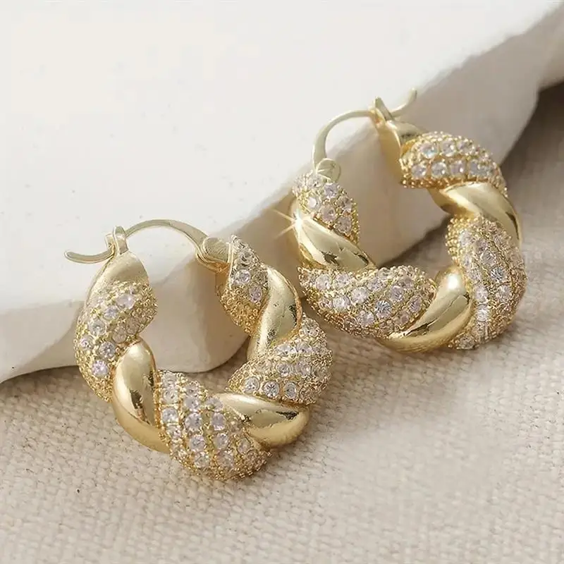 Huitan Edle Damen-Creolen in Goldfarbe für Hochzeiten und Partys, gedrehtes Design mit glänzenden Zirkonia-Steinen, modische Accessoires, schicker Schmuck