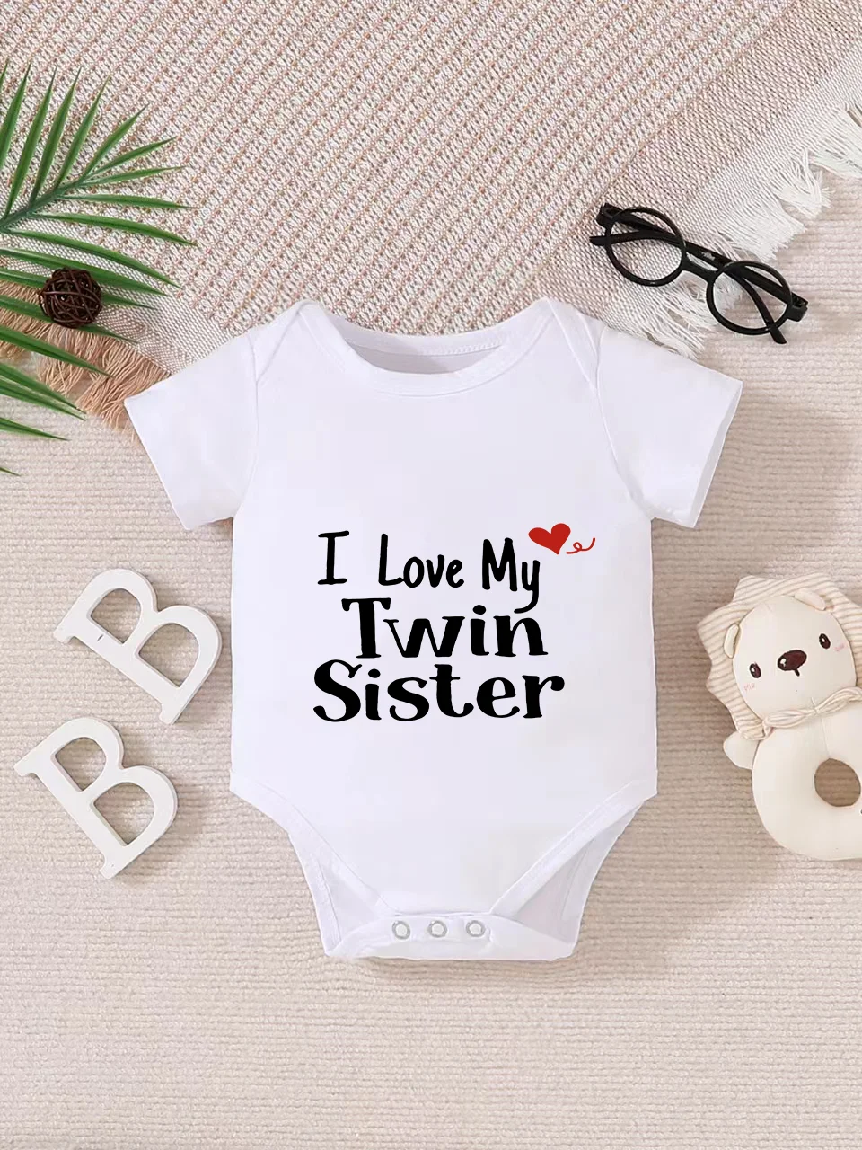 Playful letter-printed baby short-sleeve triangle bodysuit. Button closure for easy dressing, machine washable