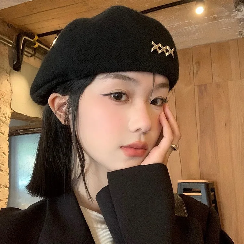 

2024 New woolen black cross metal logo decorated winter warm beret for women dark personality painter hat