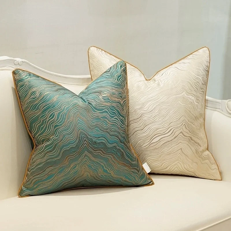 Green and beige flowing-line jacquard pillow covers on a sofa
