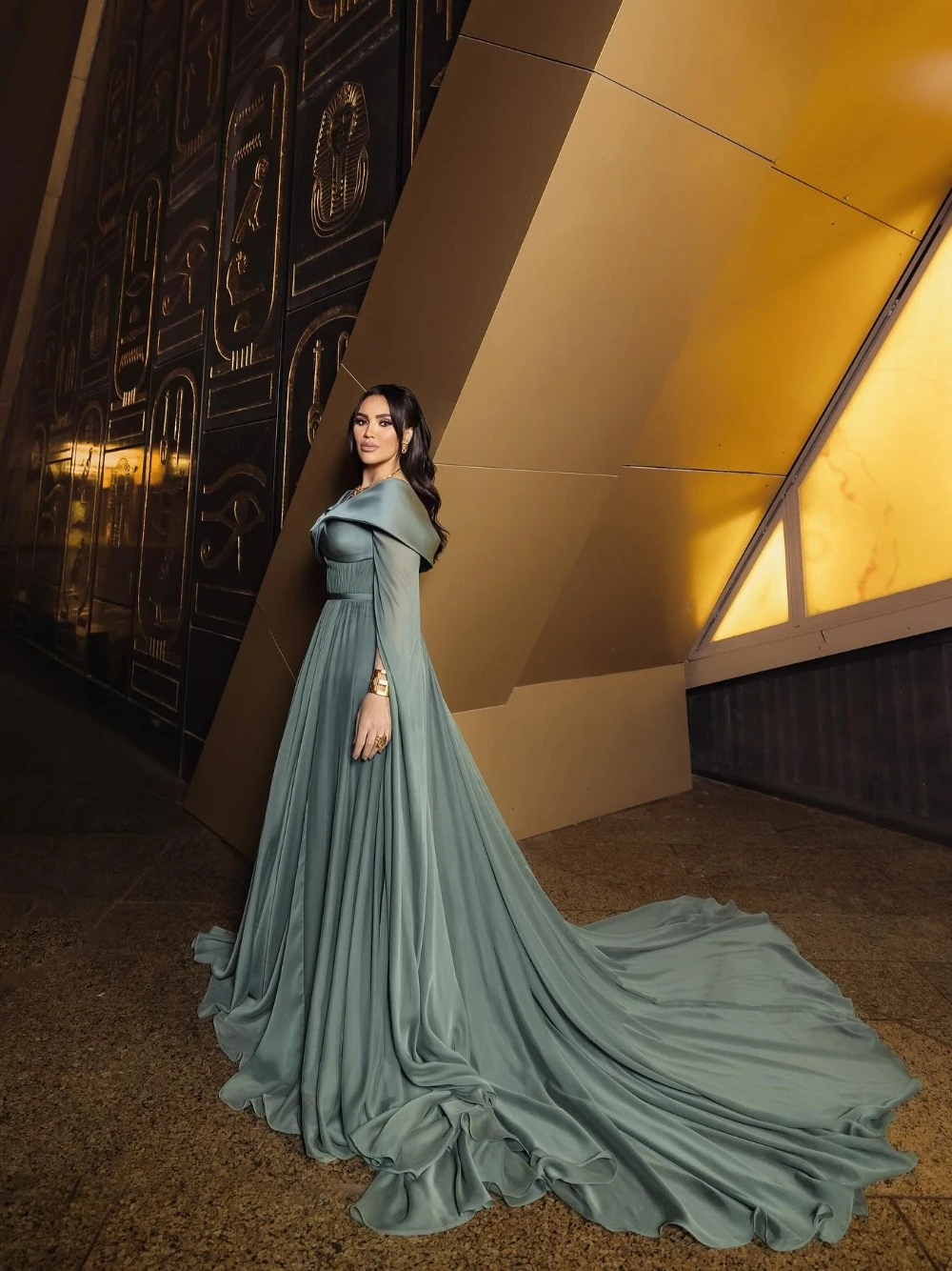 ชุดราตรีสไตล์อียิปต์โบราณสีเขียวอมฟ้า แขนเคป จับจีบ สง่างาม แบบอาหรับ พร้อมชายกระโปรงยาวแบบดราม่า สามารถสั่งตัดได้