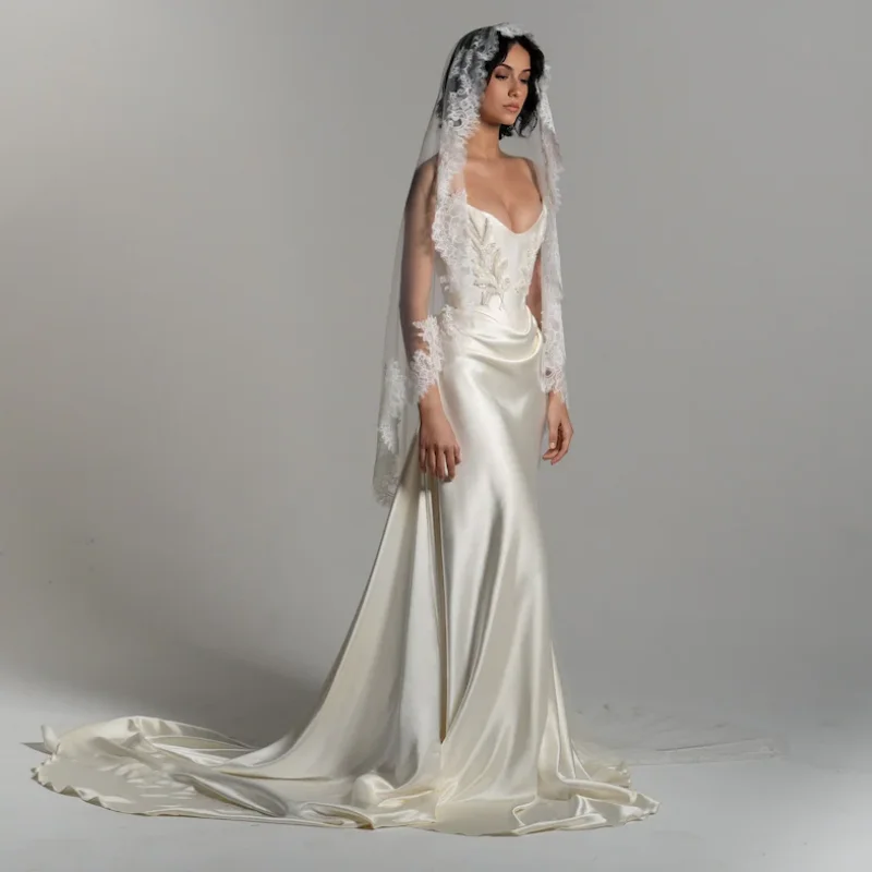 Suknia ślubna katedralna z satyny w kolorze białej kremowej, drapowana, z gorsetem w talii, z trenem do ziemi, model 2025, szyta na miarę.