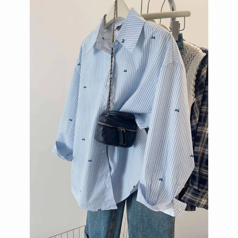 เสื้อเชิ้ตลายทางสีฟ้า เสื้อเชิ้ตแขนยาวพิมพ์ลายโบว์สไตล์เกาหลีลำลองสำหรับผู้หญิง