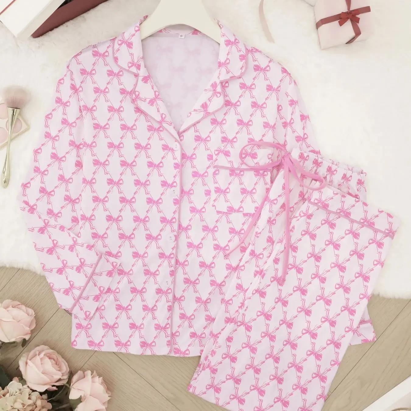 

Розовый пижамный комплект с принтом в виде бантиков, с длинными рукавами, лацканами, кардиганом, длинными брюками, можно носить как домашний костюм из двух предметов.