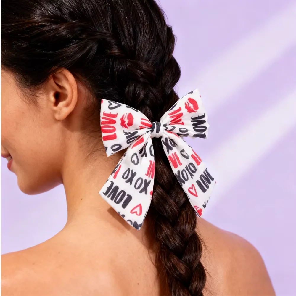 PESENAR With a pink heart lipstick and monogram on a white background this hair accessory is perfect for Valentine's Day