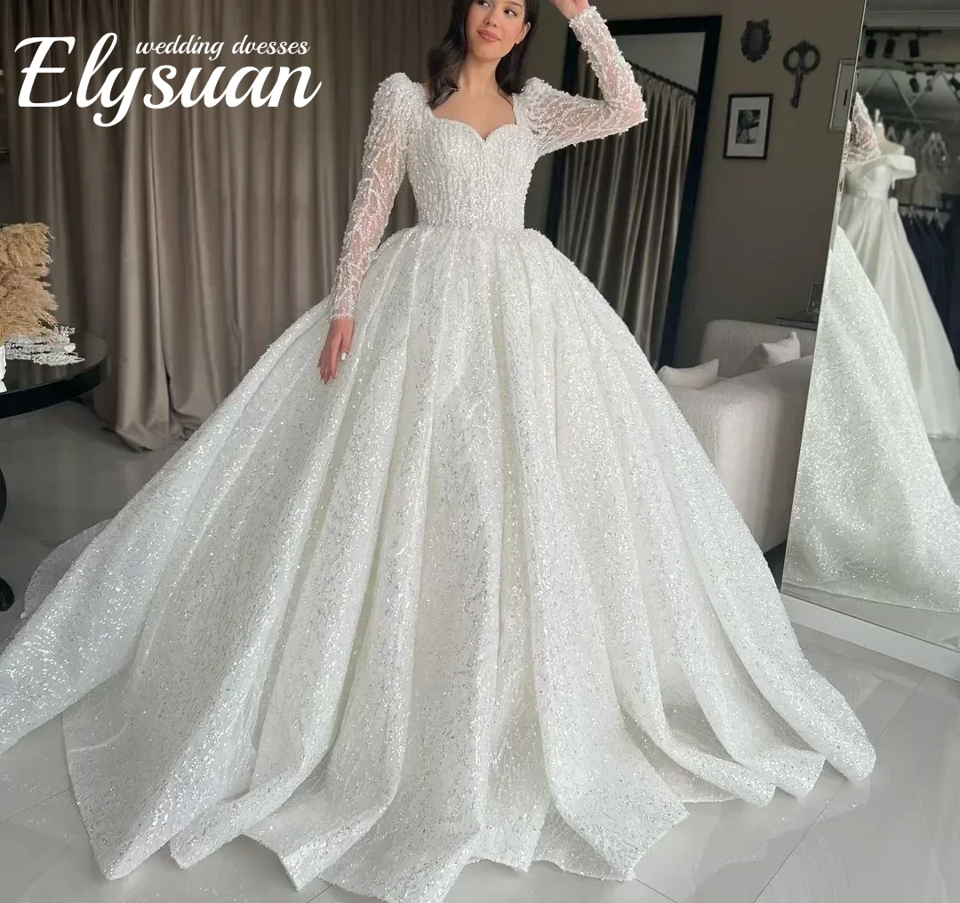 Gaun Pengantin Model Ball Gown Berkilau dengan Aksen Sweetheart, Lengan Panjang, Aplikasi Manik-Manik, dan Renda