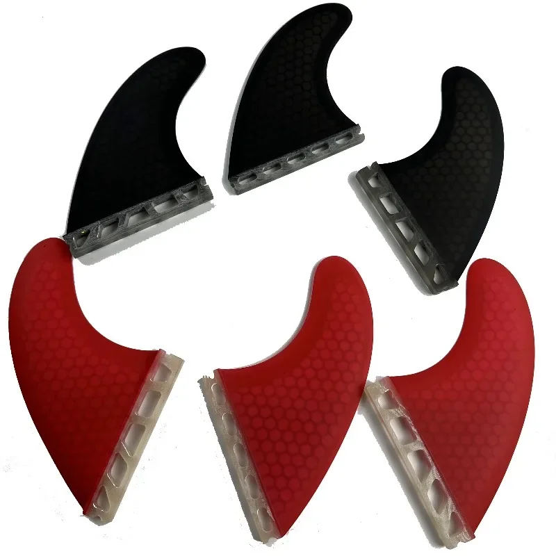 

High-performance custom colored short board fins for use on black and red surfboards