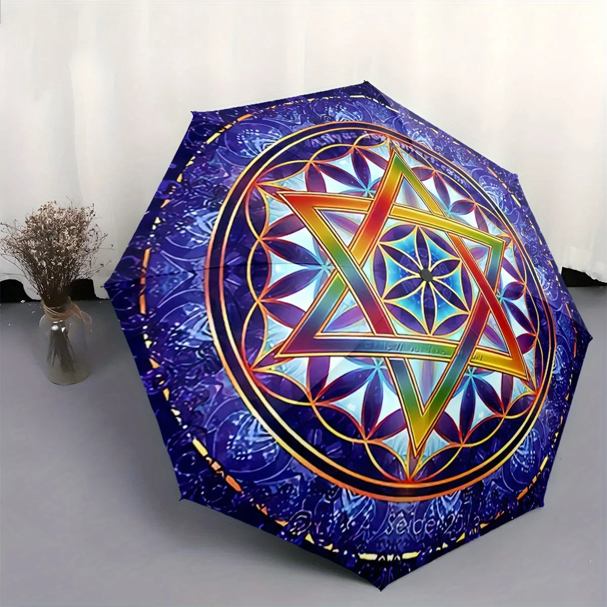 

Automatic Folding Umbrella A colorful Star of David within a geometric floral pattern. Portable collapsible design, casual out