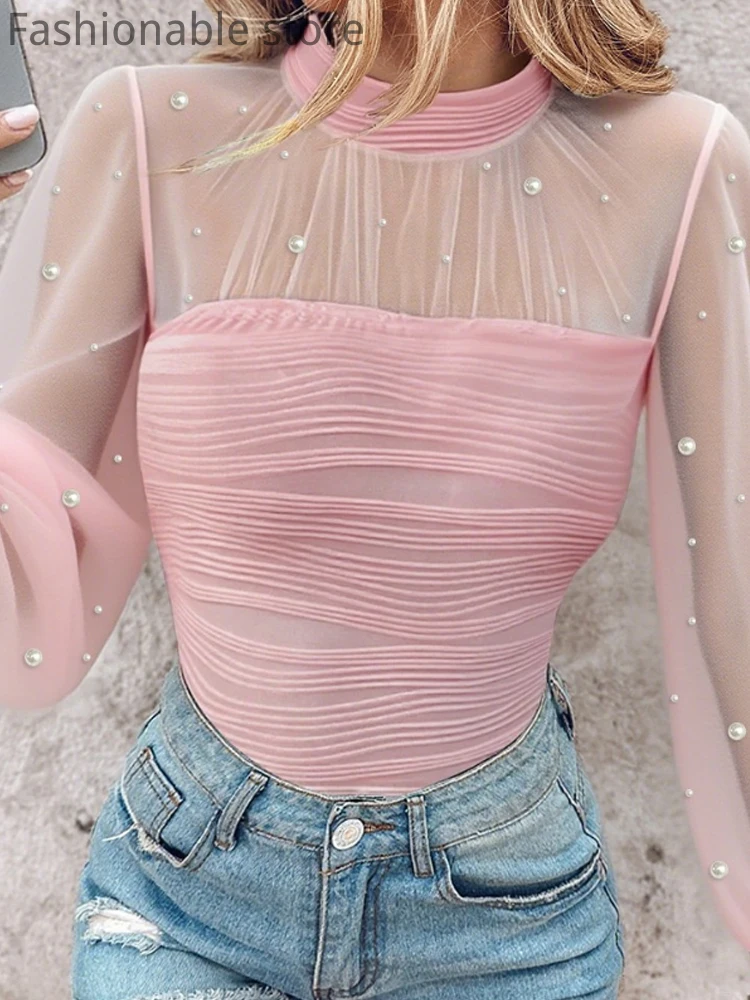 

Жемчужный декор, высокая шея, прозрачная сетка, тонкий топ со рюшами и открытой спиной