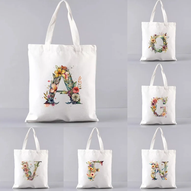 

Художественная белая холщовая сумка через плечо с акварельным цветочным буквенным принтом, подходящая для женского повседневного использования