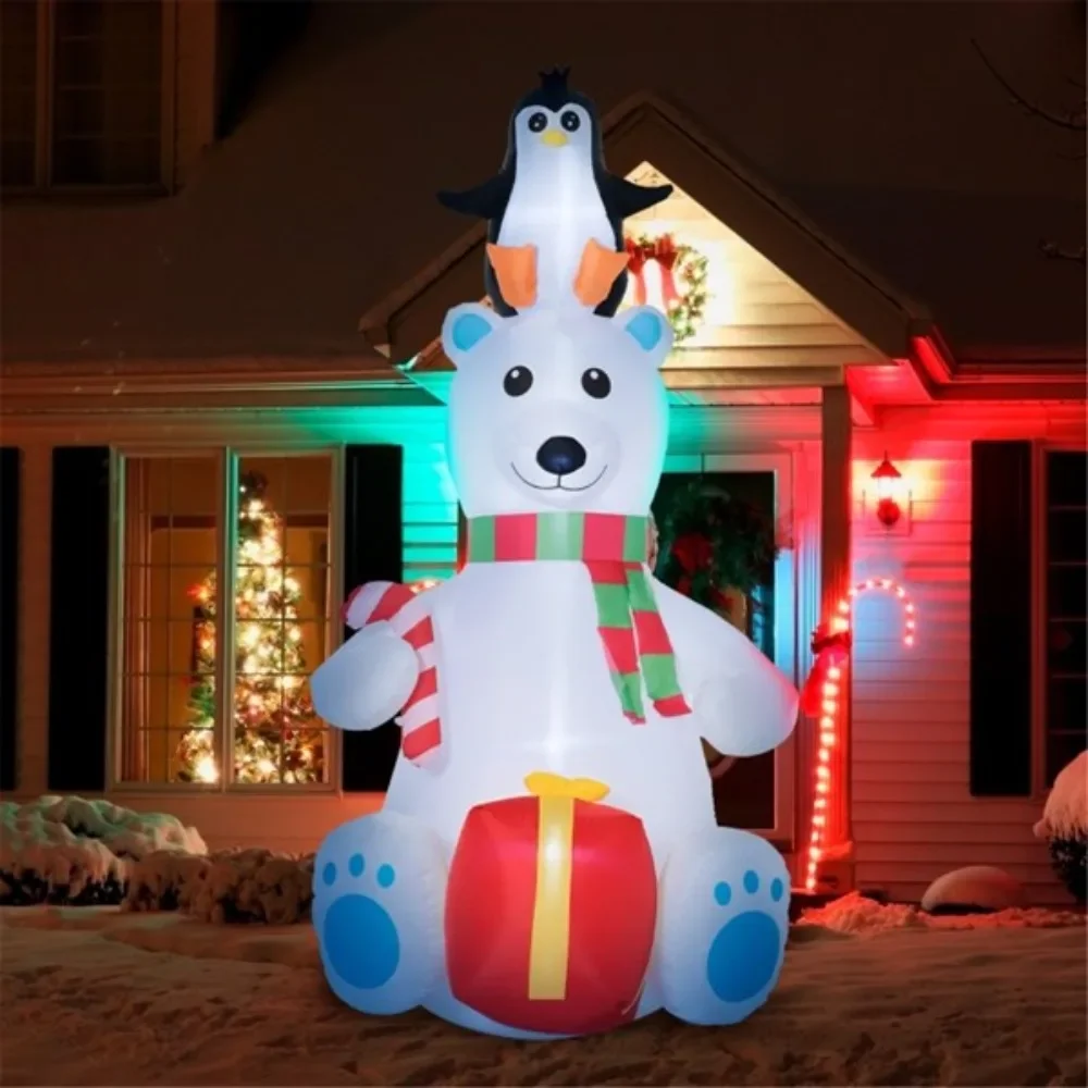 Christmas polar bear with a penguin on its head cane candy and an inflatable gift box put together a cohesive Christmas display